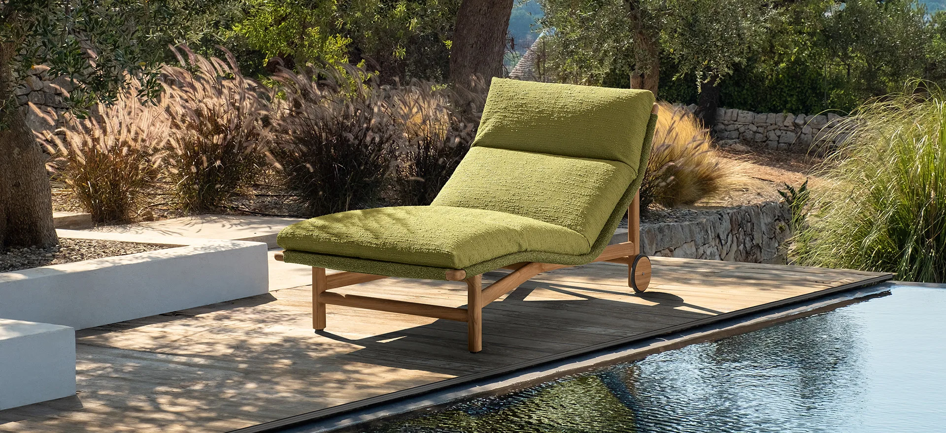 A Talenti Jun lounger beside a pool at dusk